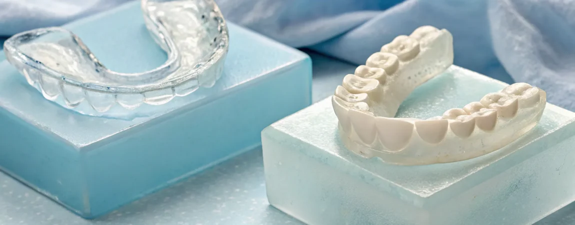 A custom mouthguard for snoring and apnea next to its dental mold.