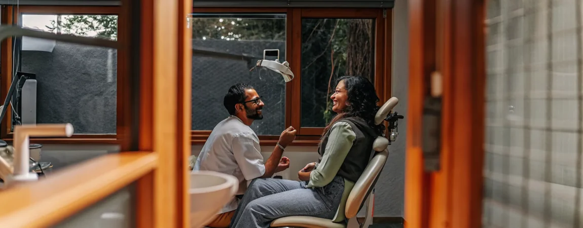 A dentist explaining custom oral appliance therapy options to a patient in a modern sleep medicine clinic